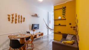 A dining area with a round table, chairs, and a television on the wall. - 2BR Apt Just 7 Mins to Copacabana Beach Br502 (Rio de Janeiro)