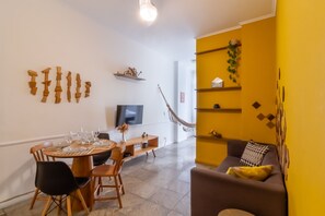 A dining area with a round table, chairs, and a television on the wall. - 2BR Apt Just 7 Mins to Copacabana Beach Br502 (Rio de Janeiro)