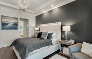 A modern bedroom with a large bed, bedside lamps, and a view of the sea through a window. - Private Pool, Walk to Grayton Beach- Grayton Pointe by Royal Destinations (Santa Rosa Beach)