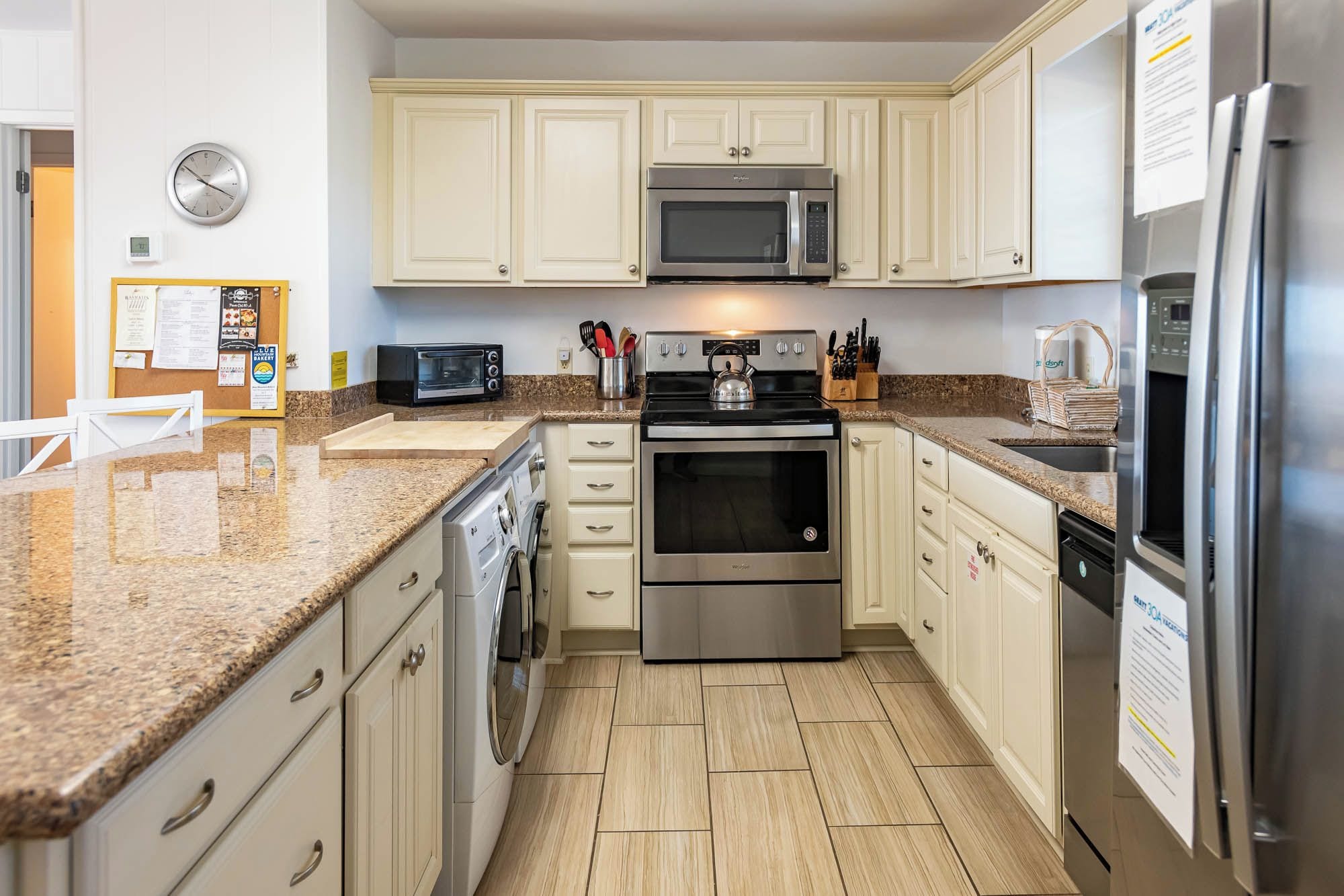 A kitchen with a microwave, oven, toaster, and refrigerator.