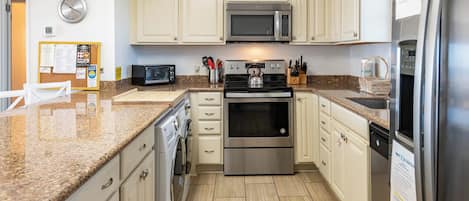 A kitchen with a microwave, oven, toaster, and refrigerator.
