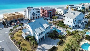 Un resort costero con varias edificaciones, una piscina y vista al océano.