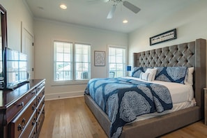 A bedroom with a large bed, a dresser, and a ceiling fan. - Private Pool, Near Beach & State Park- Lucky Dog by Royal Destinations (Santa Rosa Beach)