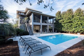 A two-story building with a swimming pool, outdoor seating, and a staircase leading to the upper level. - Private Pool, Near Beach & State Park- Lucky Dog by Royal Destinations (Santa Rosa Beach)