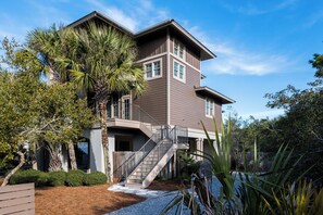 A two-story house with a balcony, a staircase, and a well-maintained garden. - Private Pool, Near Beach & State Park- Lucky Dog by Royal Destinations (Santa Rosa Beach)
