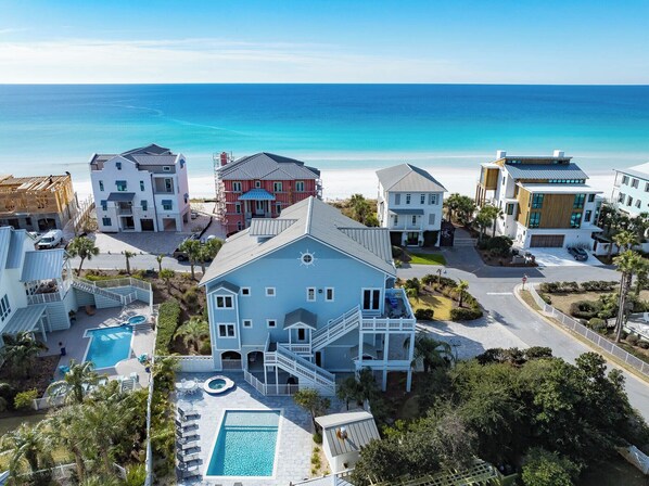 A coastal residential area with multiple houses, a swimming pool, and a view of the ocean. - Gulf Views, Steps From Beach, Elevator- Mimosa Mornings by Royal Destinations (Santa Rosa Beach)