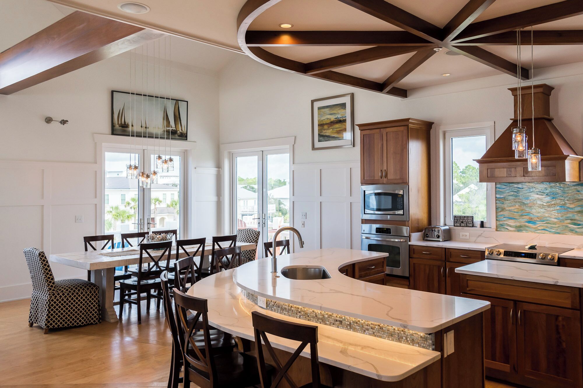 A spacious kitchen with a large island, wooden cabinets, and modern appliances.