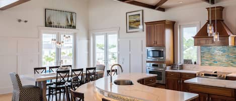 A spacious kitchen with a large island, wooden cabinets, and modern appliances.