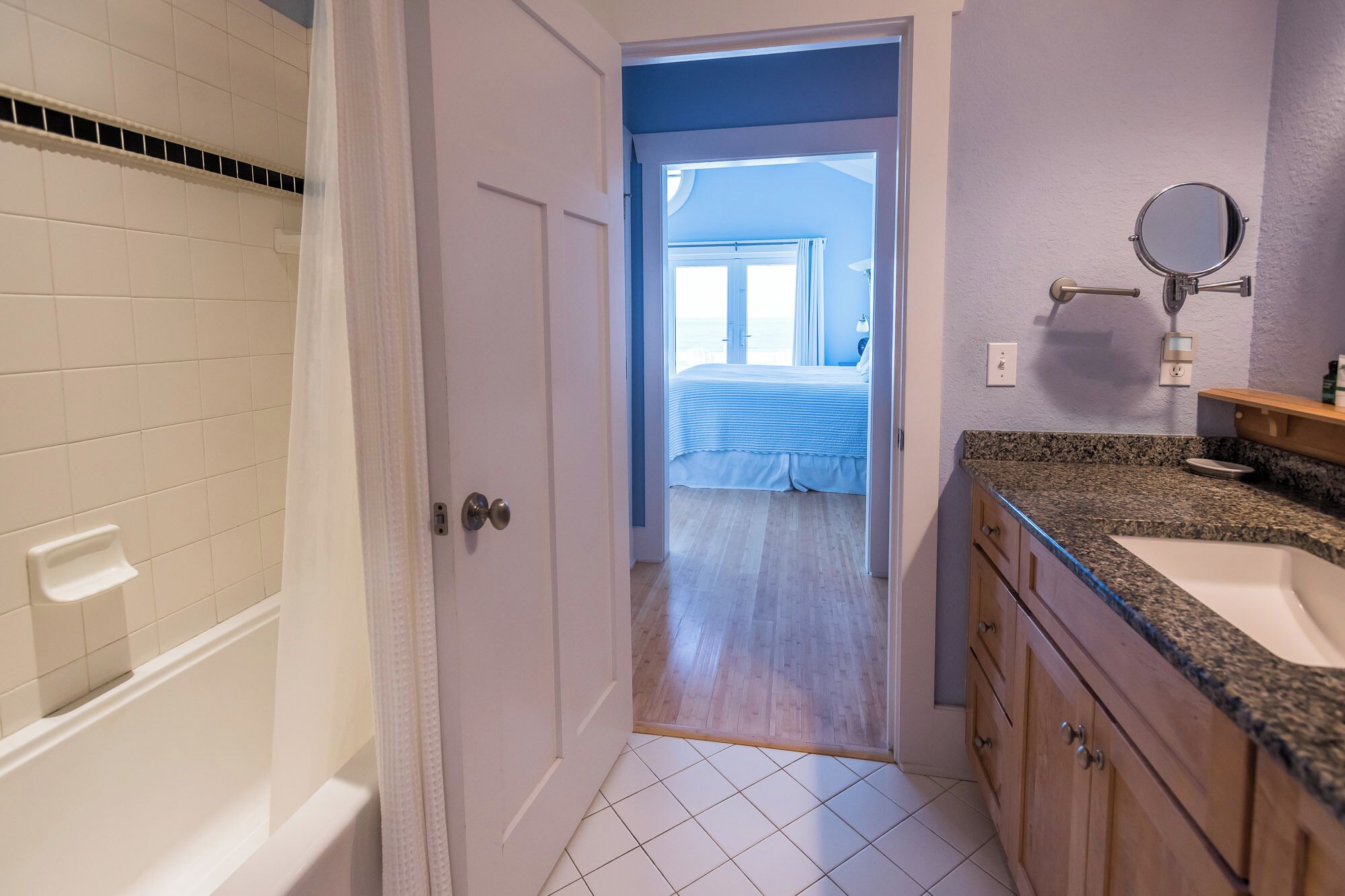 A bathroom with a bathtub, a sink, and a mirror.