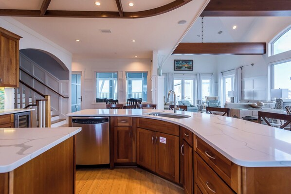 Una cocina amplia con una isla grande, armarios de madera y lavavajillas.