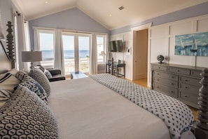 A bedroom with a large bed, a desk, a TV, and a view of the ocean. - Gulf Views, Steps From Beach, Elevator- Mimosa Mornings by Royal Destinations (Santa Rosa Beach)