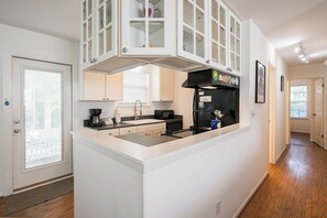 A modern kitchen with white cabinetry, a black refrigerator, and a built-in microwave. - Pet Friendly with Pool, Near Beach & Seaside- Moondance by Royal Destinations (Santa Rosa Beach)