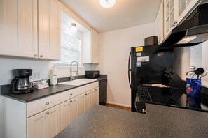A kitchen with a black refrigerator, a coffee maker, and a sink. - Pet Friendly with Pool, Near Beach & Seaside- Moondance by Royal Destinations (Santa Rosa Beach)
