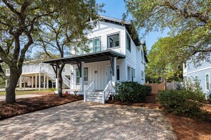 A two-story house with a covered porch and a brick driveway. - Private Pool, Steps From Beach Access- Ocho Cinco by Royal Destinations (Santa Rosa Beach)