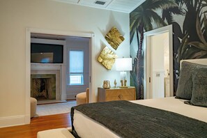 A bedroom with a bed, a nightstand, a lamp, a wall-mounted TV, and a fireplace. - Seaside Home w/ Rooftop Gulf Views- Off the Bucket List by Royal Destinations (Santa Rosa Beach)