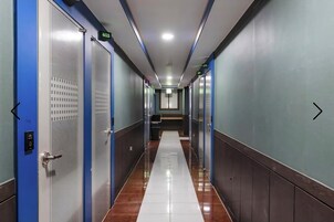 A corridor with doors on both sides, a tiled floor, and a bench in the center.