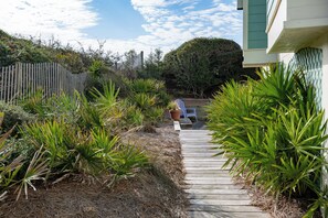 A wooden pathway leading to a house with a fenced backyard. - Gulf Front with Private Beach Access- Port of CAW by Royal Destinations (Santa Rosa Beach)