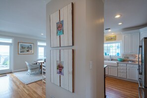 A kitchen with white cabinets, a stainless steel refrigerator, and a window with a view. - Gulf Front with Private Beach Access- Port of CAW by Royal Destinations (Santa Rosa Beach)