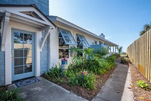 A residential property with a covered porch, a pathway leading to the entrance, and a wooden fence. - Gulf Front w/ Private Beach Access- Sea Turtle Cottage by Royal Destinations (Santa Rosa Beach)