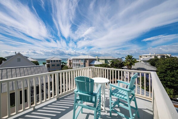 A balcony with a view of the ocean, turquoise chairs, and a small table. - Private Pool, Gulf Views, Near Gulf Place- Serendipity by Royal Destinations (Santa Rosa Beach)