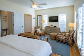 A bedroom with a bed, two wicker chairs, a dresser, a television, and a ceiling fan. - Private Pool, Gulf Views, Near Gulf Place- Serendipity by Royal Destinations (Santa Rosa Beach)