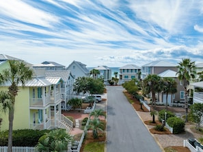 A coastal residential area with houses featuring balconies and a paved street.