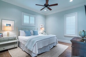 A bedroom with a bed, two bedside tables, a nightstand, a globe, and a ceiling fan. - Private Pool, Steps From Beach & Seaside- Sunday Morning (Santa Rosa Beach)