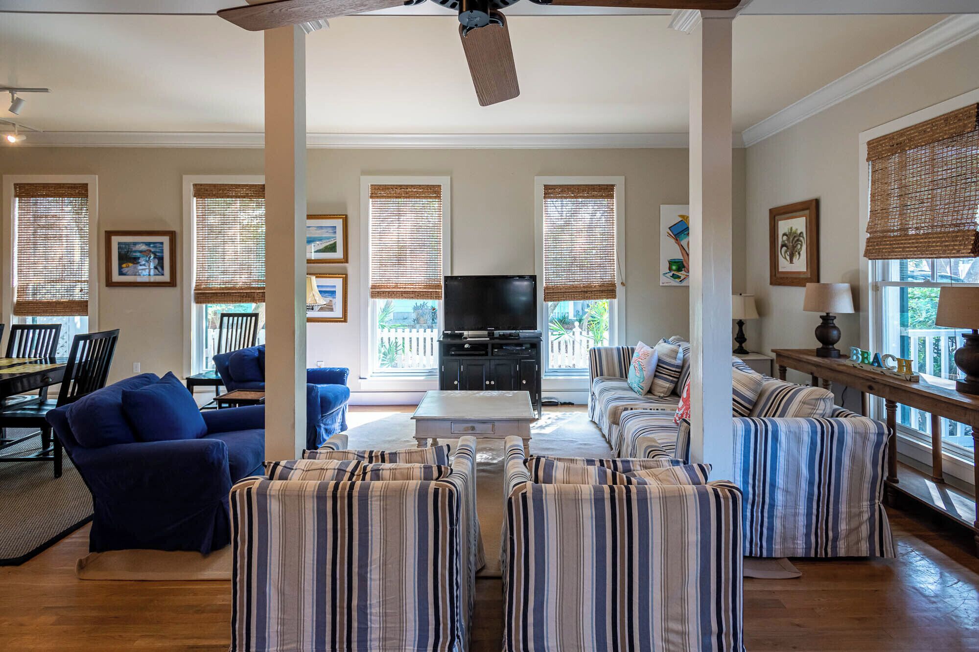 A living room with a TV, sofas, a coffee table, and a dining area with chairs and a table.