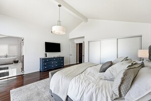 A bedroom with a large bed, a dresser, a television, and a walk-in closet. - Classic California Retreat (Laguna Niguel)