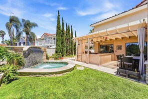A backyard with a hot tub, outdoor seating, and a pergola. - Classic California Retreat (Laguna Niguel)