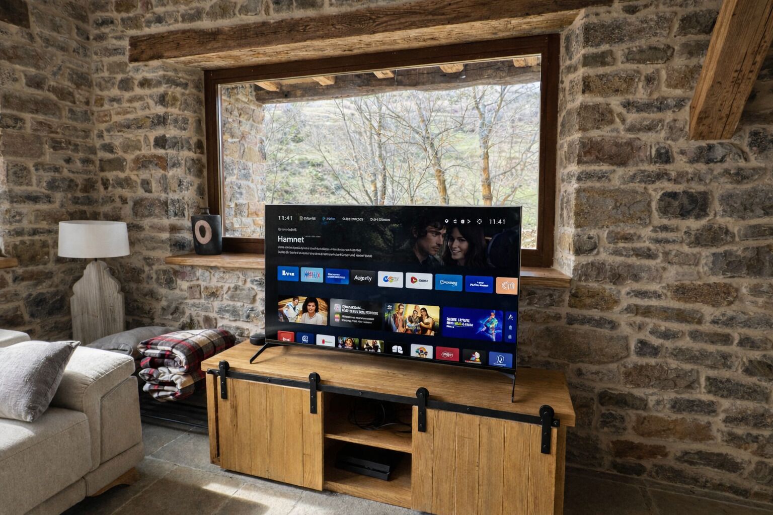 Een televisie op een houten standaard in een kamer met stenen muren en een raam.