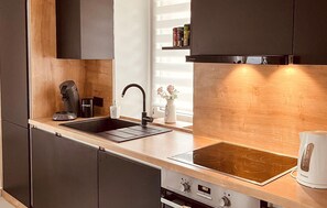 A modern kitchen with a black faucet, a built-in oven, and a wooden countertop. - Stunning home in Moravice with sauna (Moravice)