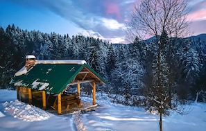 A wooden cabin with a green roof, surrounded by snow-covered trees and a mountainous backdrop. - Stunning home in Moravice with sauna (Moravice)