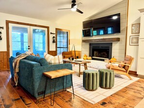 A living room with a blue sofa, wooden coffee table, and a fireplace.