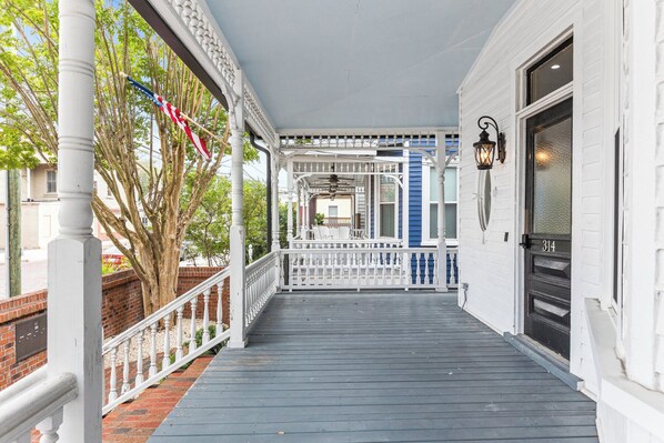 A covered porch with a white railing, a brick wall, and a blue door. - 6br, 4ba, sleeps 16 - DT Wilm, Walk to everything! (Wilmington)