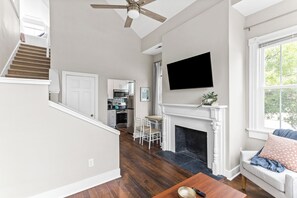 A spacious living area with a fireplace, a flat-screen TV, and a staircase leading to a kitchen. - 6br, 4ba, sleeps 16 - DT Wilm, Walk to everything! (Wilmington)