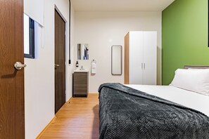 A bedroom with a bed, a wardrobe, a mirror, and a bathroom with a sink and towel rack. - 2 bedrooms | Polanco | Relax (Ciudad de México)