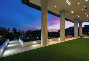 An outdoor area with concrete pillars, artificial grass, and seating. - Luxe Skyline in Midtown Atlanta (Atlanta)