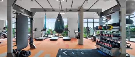 A gym with exercise equipment, a punching bag, and a weight rack.