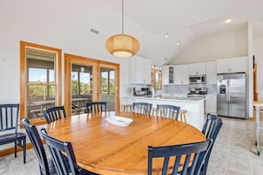 A modern kitchen with white cabinets, stainless steel appliances, and a large island.