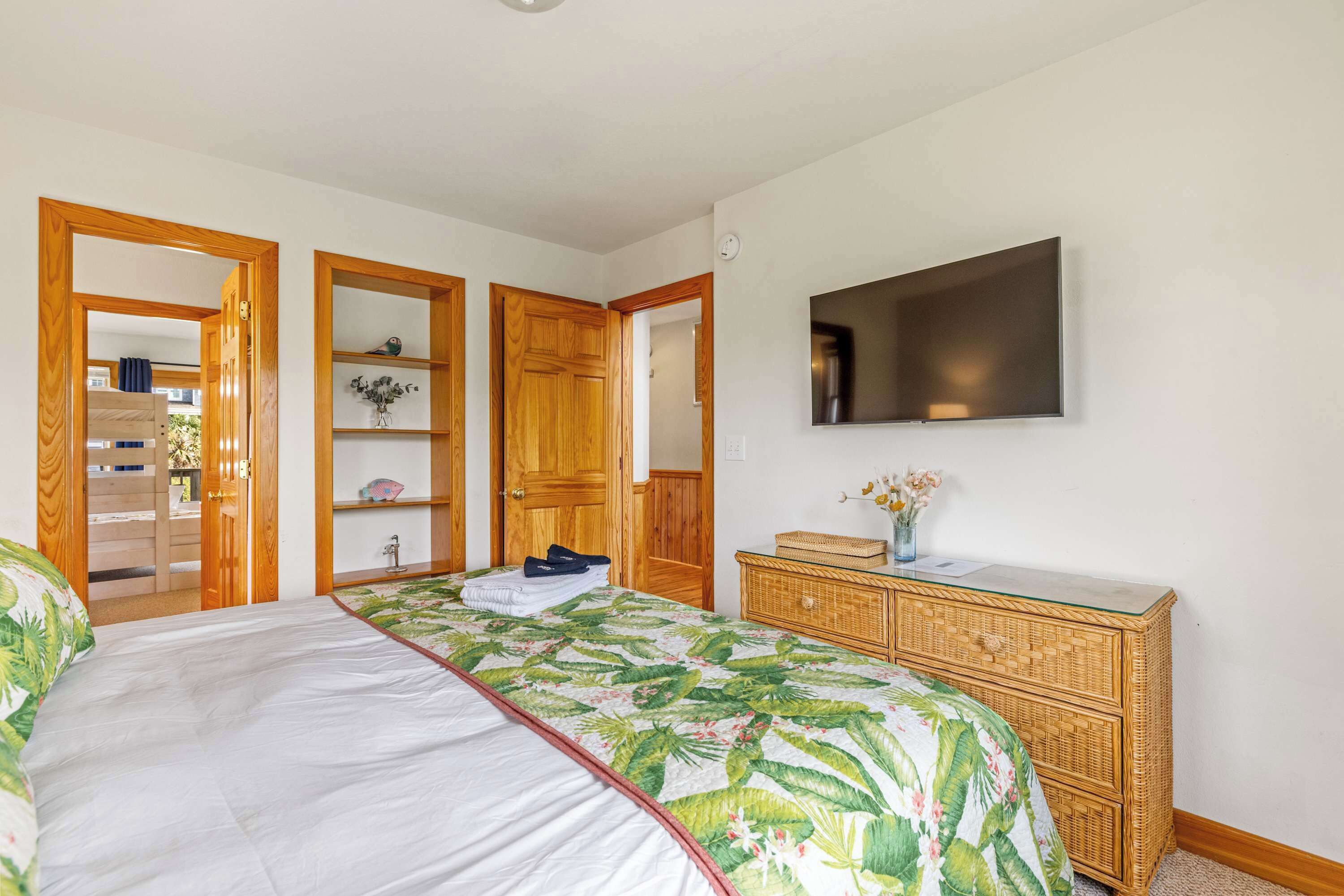 A bedroom with a bed, a dresser, a television, and a wardrobe.
