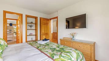 A bedroom with a bed, a dresser, a television, and a wardrobe.