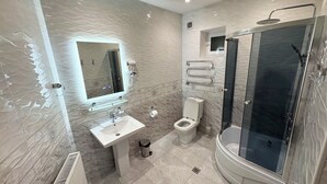 Un bagno moderno con lavandino, WC e cabina doccia in vetro.