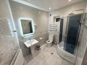 A modern bathroom with a sink, toilet, and glass-enclosed shower. - Guest-House Grand (Tashkent)