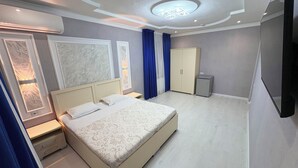Una camera da letto moderna con un letto grande, comodini, un armadio e un lampadario.