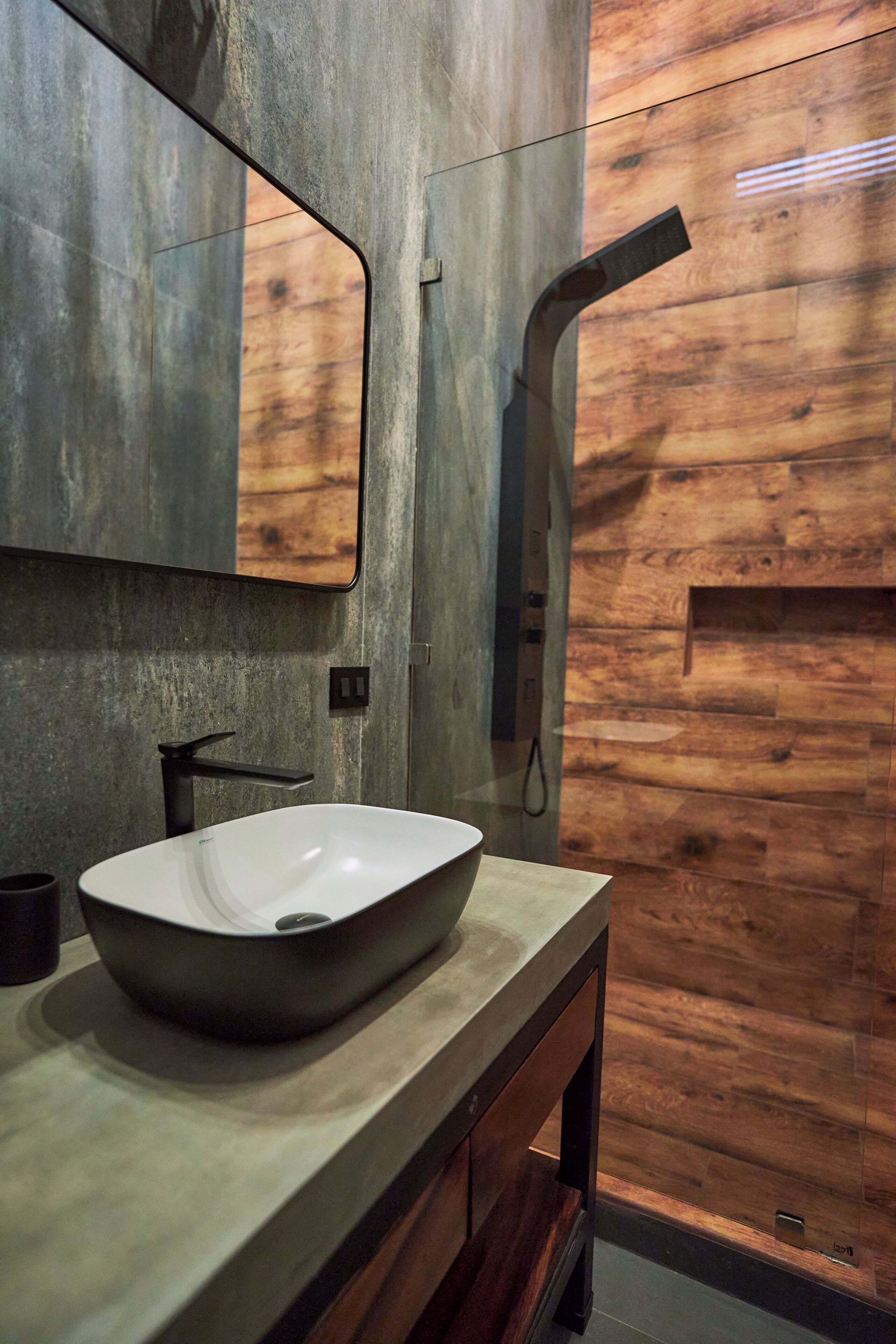 A bathroom with a large, oval-shaped vessel sink, a mirror, and a wooden wall.