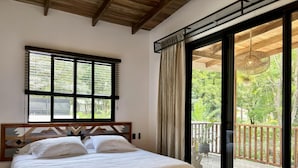 A bedroom with a bed, a window with blinds, and a view of a balcony. - Desiree Luxury Apartamentos (Malpaís)