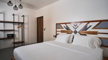 A modern bedroom with a bed, a wardrobe, a shelf unit, and a door.