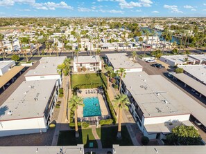 A residential area with multiple buildings, a swimming pool, and palm trees. - Litchfield Park Getaway and Pool 2BR Condo (Litchfield Park)