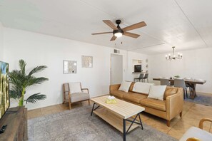 A living room with a sofa, armchair, coffee table, and a ceiling fan. - Litchfield Park Getaway and Pool 2BR Condo (Litchfield Park)